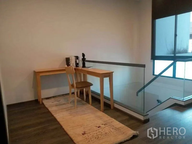 Townhouse for rent in Bang Phli, Samut Prakan - Small study corner on the landing with desk and glass balustrade.