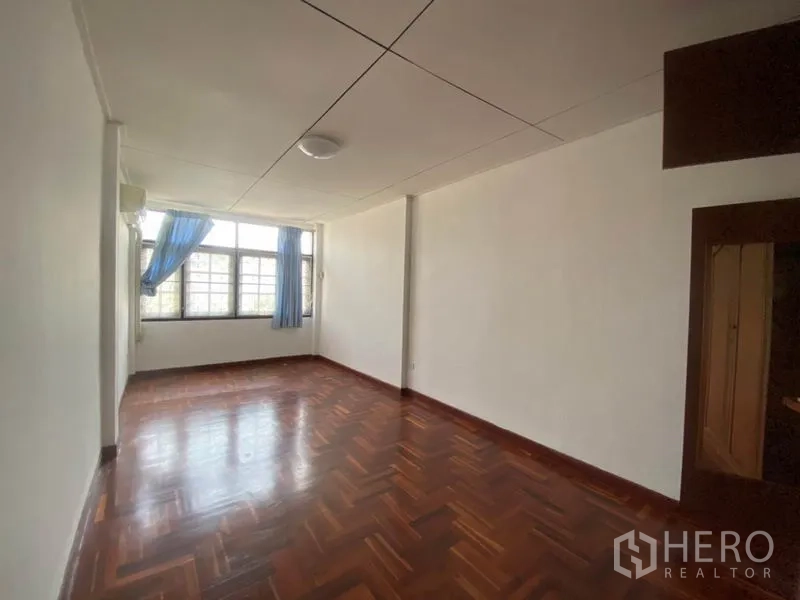 ทาวน์เฮาส์ ให้เช่าในWatthana, Bangkok - ห้องนอนสว่างด้วยหน้าต่างบานใหญ่ ม่านสีน้ำเงิน และพื้นปาร์เกต์.