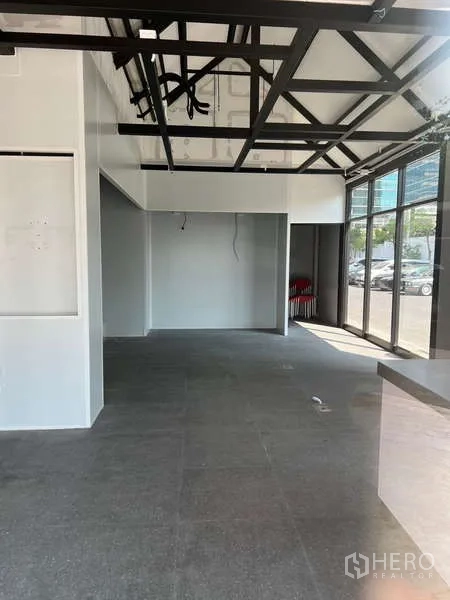พื้นที่ขายปลีก ให้เช่า - พื้นที่ภายในแบบโอเพ่นเพลน เพดานสูง โครงเหล็กสีดำและกระจกเต็มความสูง.