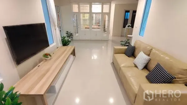Detached House for rent in Bang Phli, Samut Prakan - Bright living room with beige sofa, wall-mounted TV and built-in cabinet.