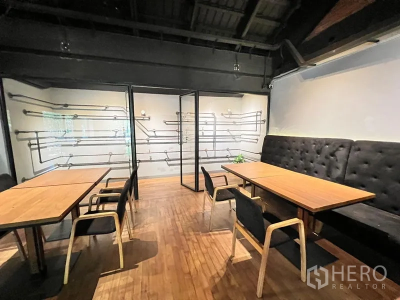 零售空间 出租在Bangkok - 温馨就餐角，长椅、木桌与玻璃隔断。