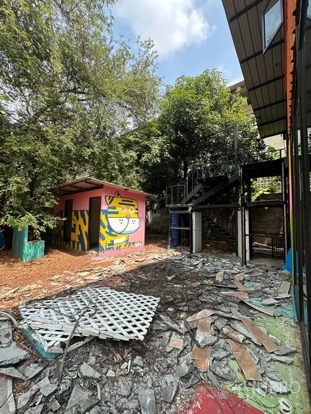 Detached House for rent in Watthana, Bangkok - Small outbuilding with a colorful mural beside exterior stairs and debris.