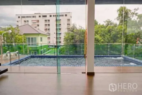 บ้าน ขายในLat Phrao, Bangkok - มุมมองผ่านผนังกระจกออกไปยังสระว่ายน้ำส่วนตัวและอพาร์ตเมนต์โดยรอบ