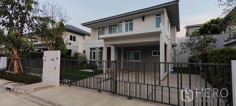 บ้าน ให้เช่าในPrawet, Bangkok - บ้านเดี่ยวสองชั้นสไตล์โมเดิร์น ด้านหน้ามีกำแพงรั้วและที่จอดรถในร่ม.