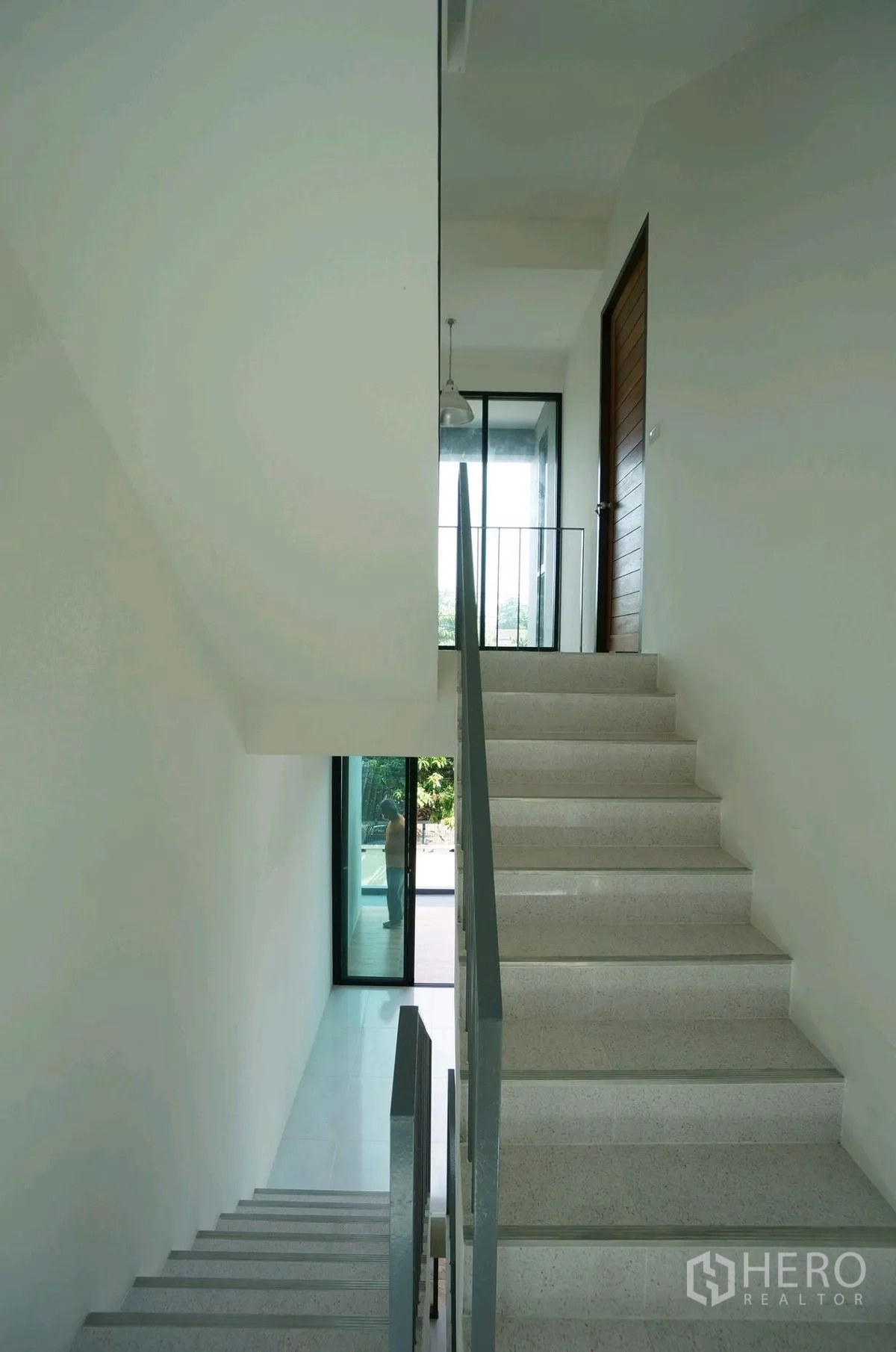 家庭办公室 for rent in Chatuchak, Bangkok - 采光良好的楼梯间，白色台阶与金属栏杆连接露台门。