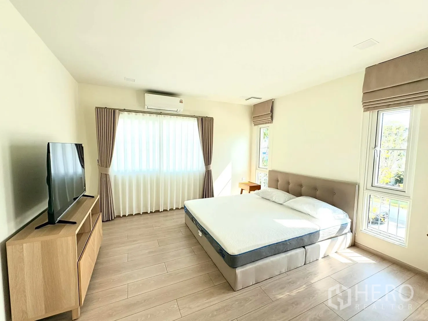 独立式住宅 for rent in Bang Phli, Samut Prakan - 主卧另一角度，床、电视柜与采光良好的木地板。
