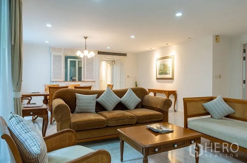 Apartment for rent in Bang Rak, Bangkok - Another view of the living area featuring rattan armchairs, sofa and wooden coffee table in an open-plan layout.