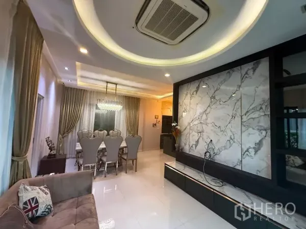 Detached House for rent or sale in Bang Phli, Samut Prakan - Open‑plan lounge and dining area with a marble feature wall, recessed lighting, chandelier and glossy tile flooring.