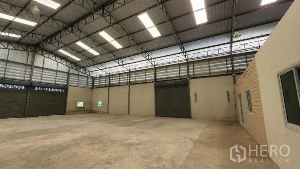 คลังสินค้า ให้เช่าในChon Buri - พื้นโกดังกว้าง มีประตูม้วนหลายบานและช่องลมบานเกล็ด