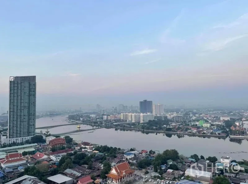 Condominium for sale in Bang Sue, Bangkok - Daytime cityscape showing river, bridge and nearby high-rise buildings.