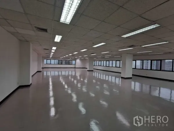 办公空间 出租在Watthana, Bangkok - 开放式办公室大空间，抛光地面、格栅天花与长窗，城市景观。