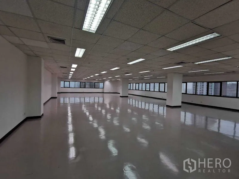 办公空间 出租在Watthana, Bangkok - 开放式办公室大空间，抛光地面、格栅天花与长窗，城市景观。