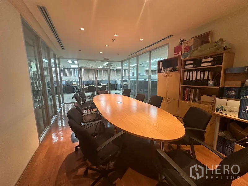 Office Space for rent - Meeting room with oval table beside glass partition overlooking work area
