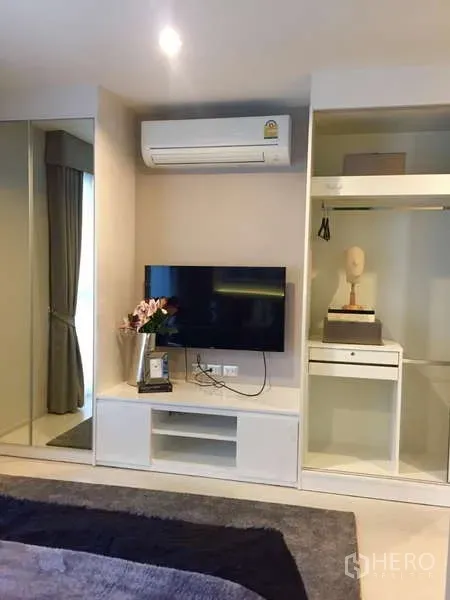 คอนโด ให้เช่าในKhlong Toei, Bangkok - ผนังห้องนอนพร้อมชั้นวางทีวี เครื่องปรับอากาศ และตู้เสื้อผ้าบิวท์อินแบบเปิด