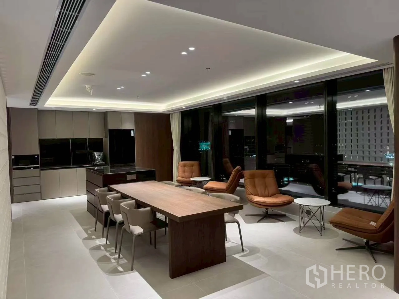 办公室 for rent in Din Daeng, Bangkok - 茶水间与休闲区，配长桌、休闲椅和落地窗的夜景。