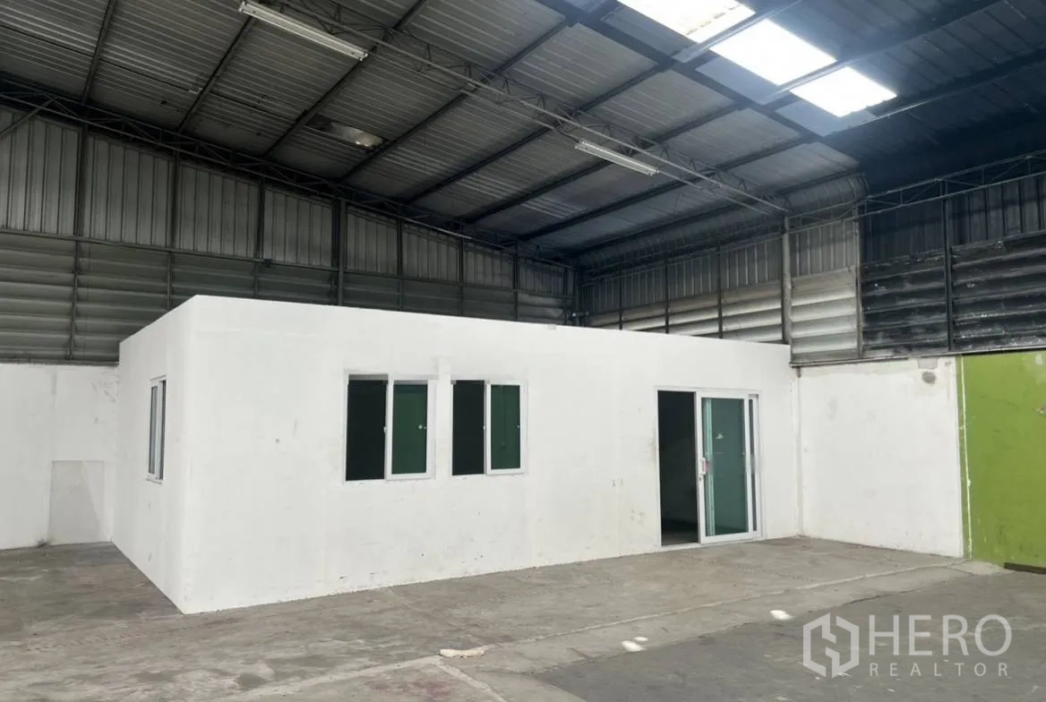 Warehouse for rent in Suan Luang, Bangkok - Built-in white office room with windows and a sliding door inside the warehouse.
