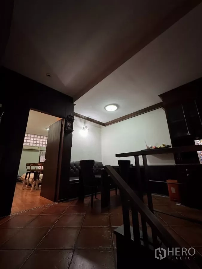 店屋 出租在Bang Rak, Bangkok - 灯光柔和的会客与餐区，皮沙发与赤陶地砖。