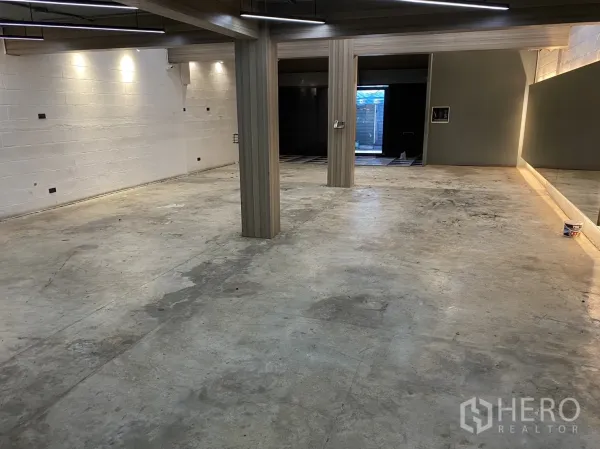 พื้นที่ขายปลีก ให้เช่าในPhaya Thai, Bangkok - ฮอลล์กว้างพื้นคอนกรีต มีเสาและไฟเส้น มีกระจกไฟซ่อน นำสู่ด้านหน้าร้าน.