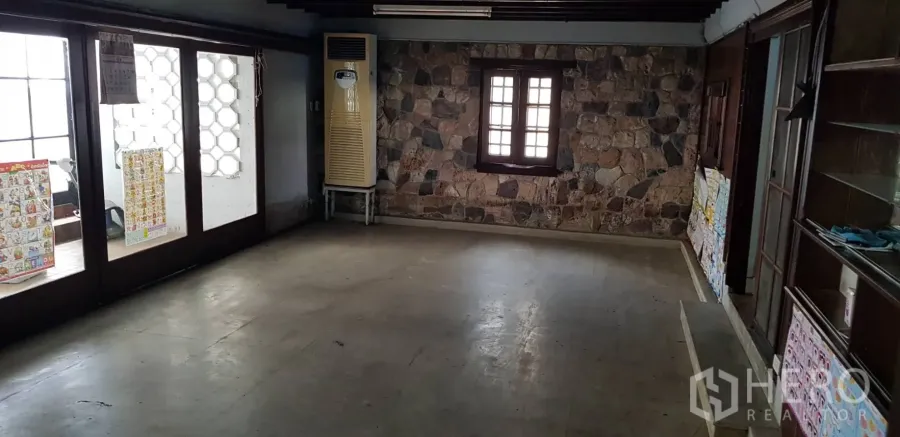 ทาวน์เฮาส์ ให้เช่าในKhlong Toei, Bangkok - ห้องชั้นล่างกว้าง ผนังหินตกแต่งและประตูกระจก ในทาวน์เฮ้าส์ย่านพระโขนง