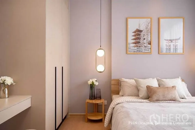 Condominium for rent in Watthana, Bangkok - Bedroom corner showing tall wardrobe, bedside table with flowers and hanging globe pendant.