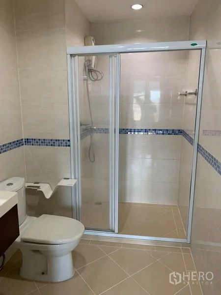 公寓 出租在Bang Rak, Bangkok - 第二浴室设玻璃淋浴房、坐便器与米色地砖。