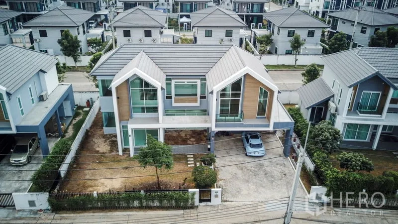 บ้าน ให้เช่าหรือขายในLam Luk Ka, Pathum Thani - ภาพมุมสูงของบ้านเดี่ยวสองชั้นสไตล์โมเดิร์นพร้อมที่จอดรถในหมู่บ้านรักษาความปลอดภัย