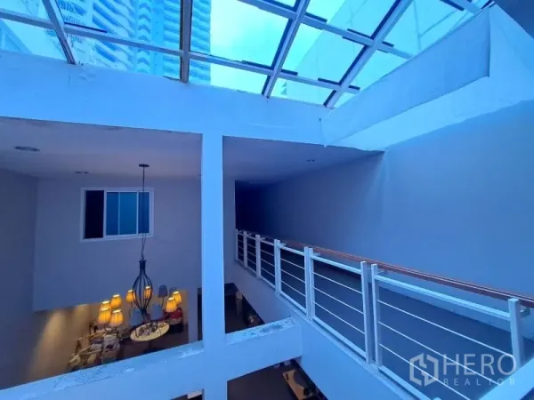 店屋 出租在Watthana, Bangkok - 大天窗下的楼层走廊，配金属栏杆。