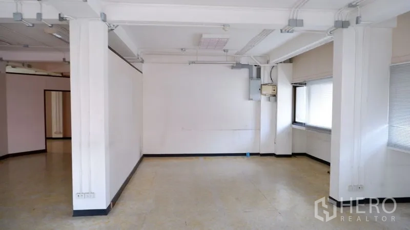 สำนักงาน ให้เช่าในWatthana, Bangkok - ห้องว่างผนังสีขาว มีเสารับแรง กล่องระบบ และหน้าต่างด้านข้างพร้อมม่าน