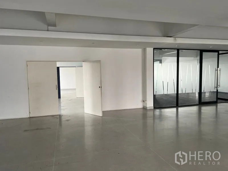 Office Space for rent in Mueang Samut Prakan, Samut Prakan - White wall with double doors and an adjacent glass-divided room.