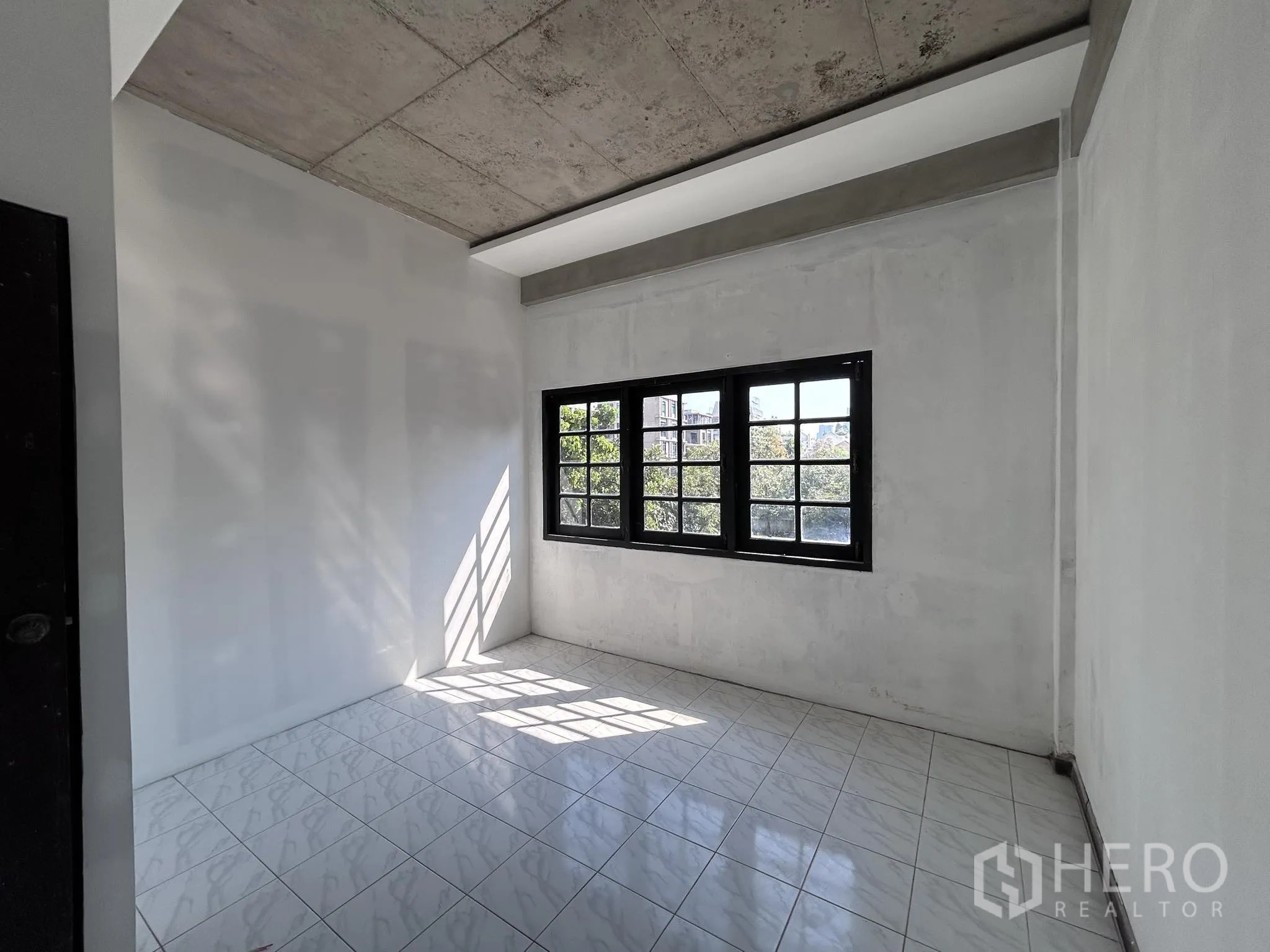 家庭办公室 for rent or sale in Watthana, Bangkok - 另一间铺砖明亮房间，宽窗采光充足。