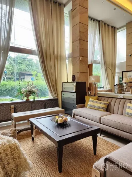 พื้นที่ขายปลีก ให้เช่าในWang Thonglang, Bangkok - โซนเลานจ์จัดแสดงพร้อมโซฟา โต๊ะกลาง ผ้าม่านยาว และวิวสวนผ่านผนังกระจก