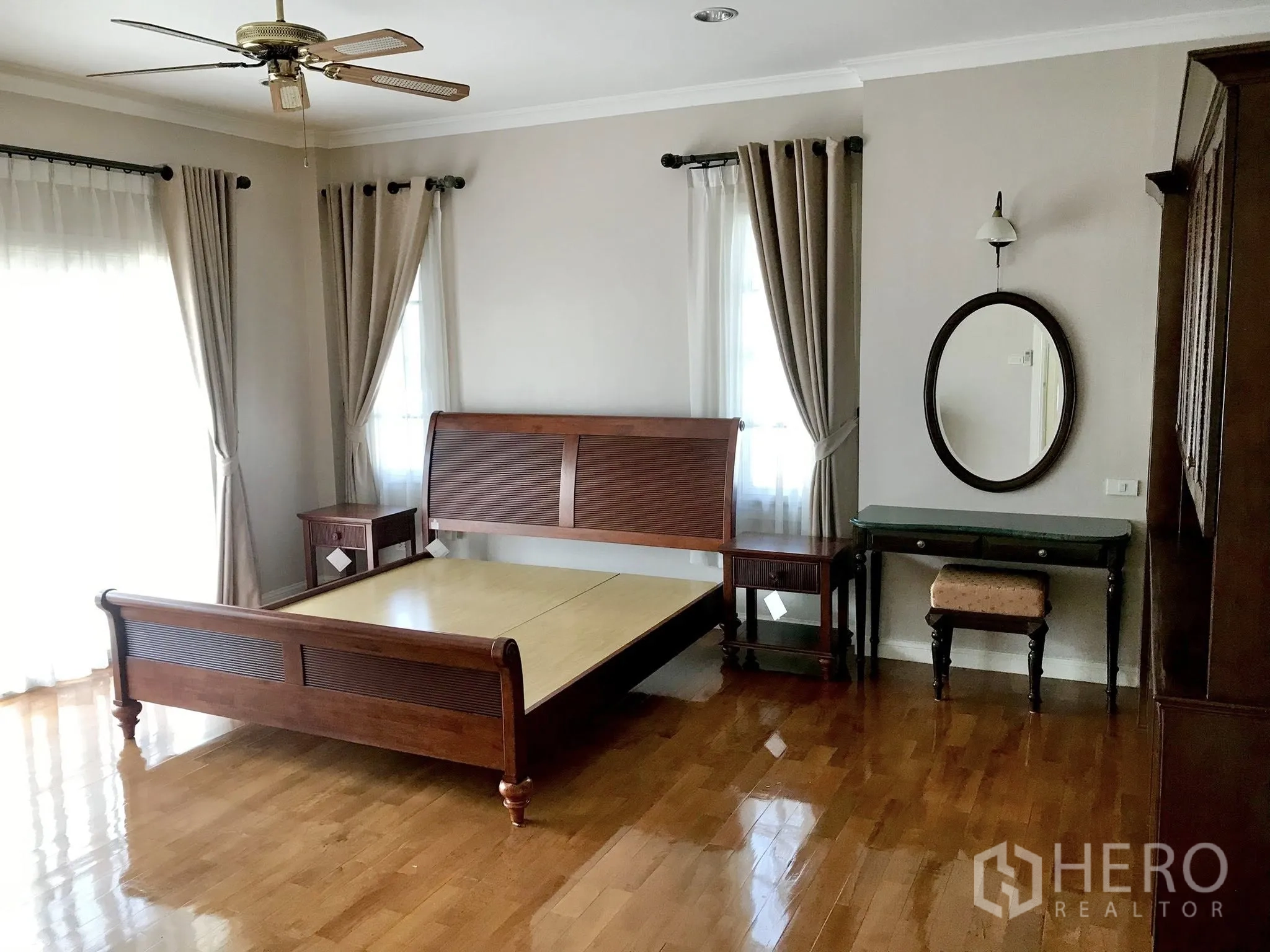 Detached House for rent in Mueang Samut Prakan, Samut Prakan - Bedroom with wooden bed frame, ceiling fan and neutral curtains.