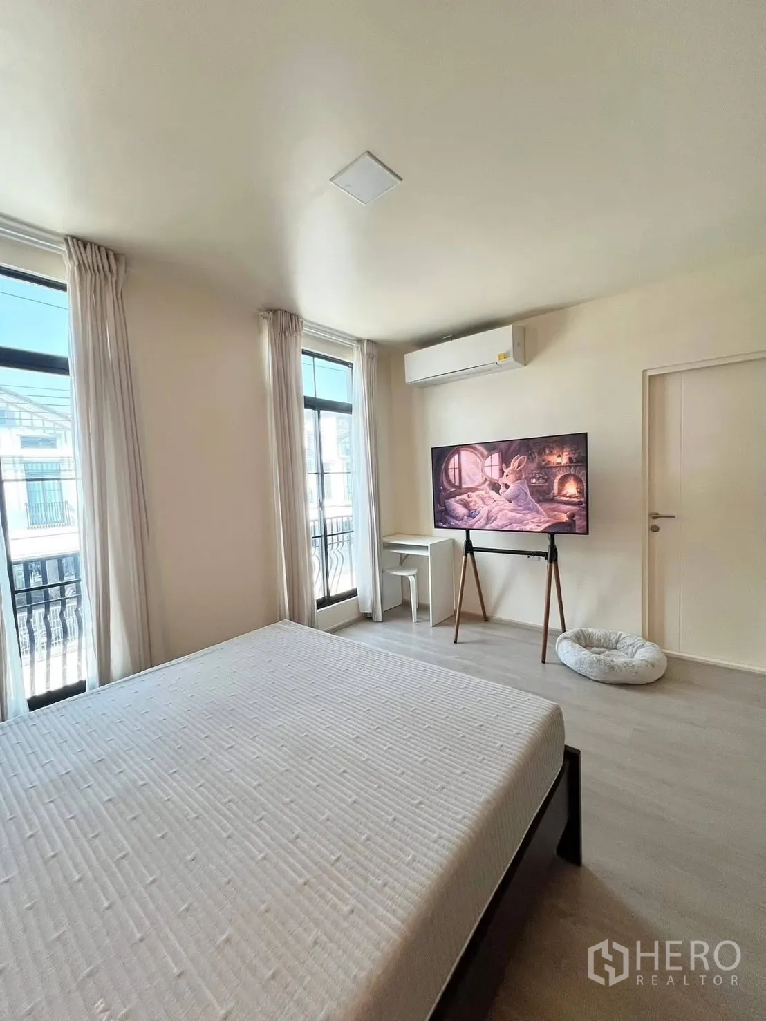 联排别墅 for rent in Bang Phli, Samut Prakan - 主卧设大窗、落地支架电视、书桌与空调。