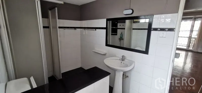 Townhouse for rent in Watthana, Bangkok - White tiled bathroom with large mirror, pedestal sink and shower zone