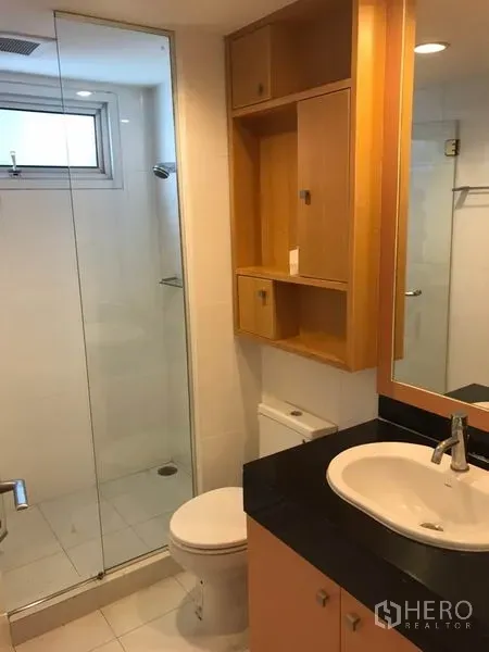 คอนโด ให้เช่าในWatthana, Bangkok - ห้องน้ำสไตล์โมเดิร์น ฝักบัวกระจก ผนังกระเบื้องขาว และเคาน์เตอร์อ่างล้างหน้าไม้