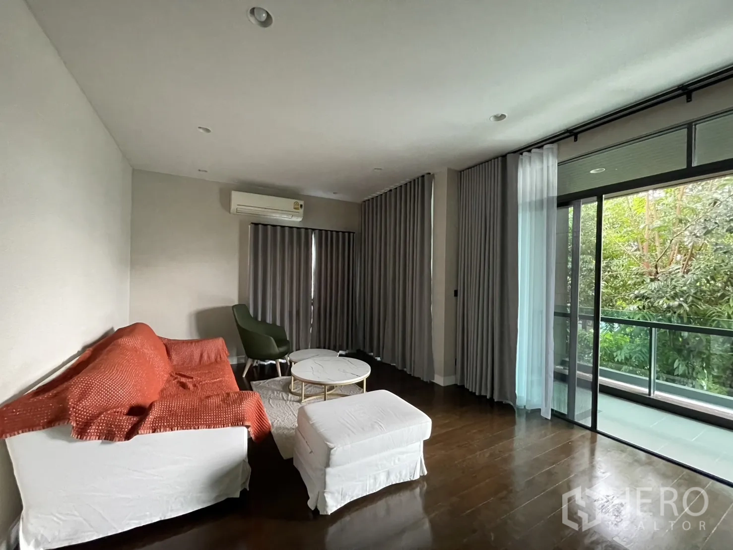 Detached House for rent in Bang Kapi, Bangkok - Lounge opening to balcony with garden views and sliding doors.