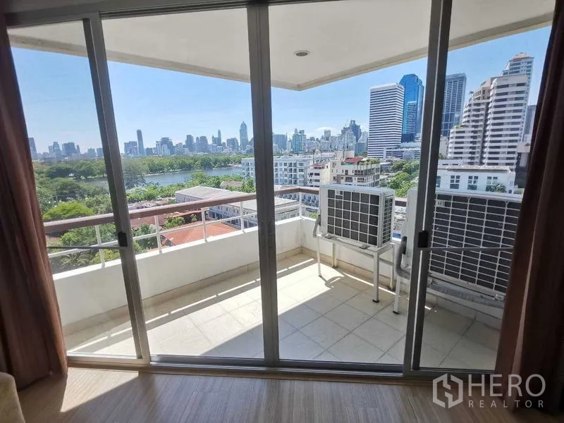 คอนโด ให้เช่าในKhlong Toei, Bangkok - ระเบียงส่วนตัวผ่านประตูกระจกบานเลื่อน เห็นวิวเมืองและสวน พร้อมคอมเพรสเซอร์แอร์