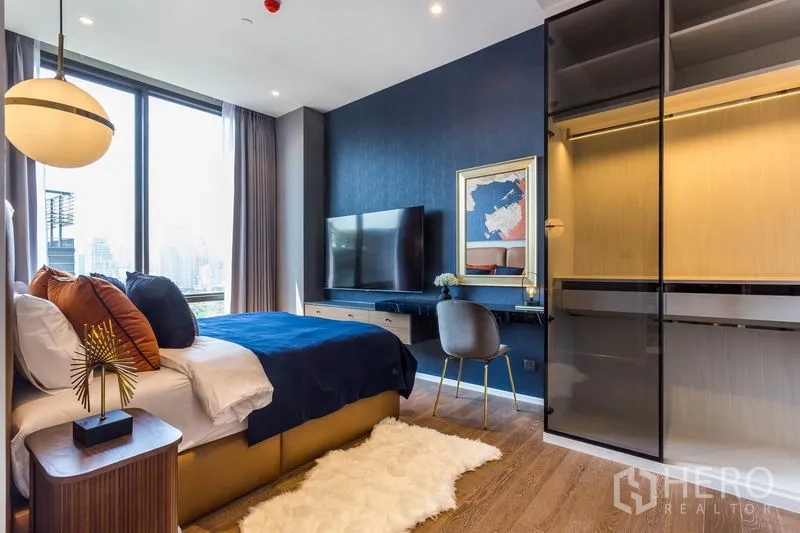 คอนโด ให้เช่าหรือขายในPathum Wan, Bangkok - ห้องนอนชมวิวเมือง พรมขนเฟอร์ และตู้เสื้อผ้าบิลท์อิน ผนังสีน้ำเงิน ในปทุมวัน กรุงเทพฯ