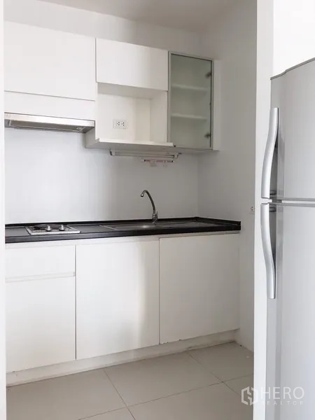 公寓 出租在Huai Khwang, Bangkok - 白色一字型厨房，橱柜、水槽、灶台、抽油烟机和冰箱