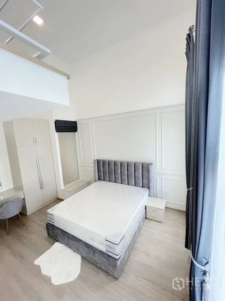 联排别墅 出租在Prawet, Bangkok - 主卧配软包床、衣柜与梳妆台，色调柔和。