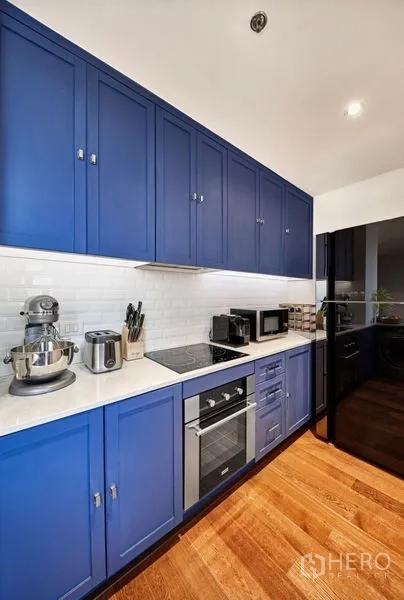 คอนโด ให้เช่าหรือขายในSathon, Bangkok - ครัวแบบแกลลอรี ตู้สีน้ำเงิน เครื่องใช้ไฟฟ้าบิวท์อิน และผนังกระเบื้องซับเวย์สีขาว