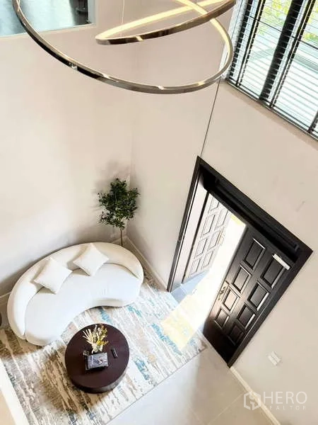 独立式住宅 出租或出售在Bang Phli, Samut Prakan - 從上方俯瞰挑高玄關，白色弧形沙發、圓形茶几與敞開的大門。