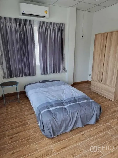 独立式住宅 出租在Mueang Nonthaburi, Nonthaburi - 明亮卧室，带空调、衣柜与木纹地面。