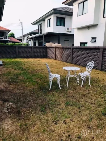 独立式住宅 出租或出售在Pathum Thani - 私家庭院草坪，白色户外桌椅