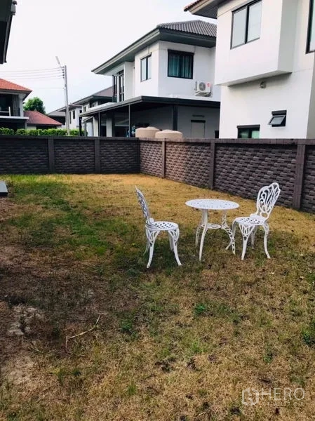 独立式住宅 出租或出售在Pathum Thani - 私家庭院草坪，白色户外桌椅