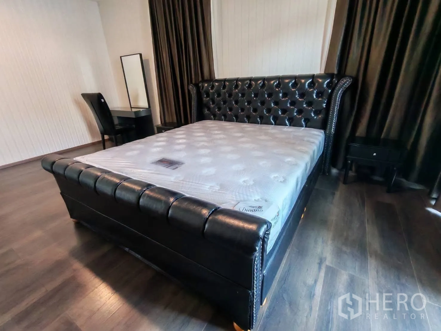 บ้านเดี่ยว for rent in Bang Phli, Samut Prakan - ห้องนอนพร้อมเตียงหนังหัวเตียงแบบหมุด บุโซฟา และผ้าม่านสีเข้ม