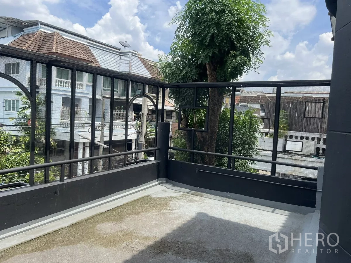 Home Office for rent in Wang Thonglang, Bangkok - Open rooftop terrace with mesh railing and leafy neighborhood views.