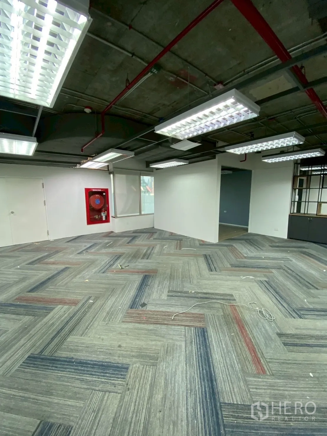 办公室 for rent in Watthana, Bangkok - 开放区域带安全设备柜、地毯砖和吊装面板灯。