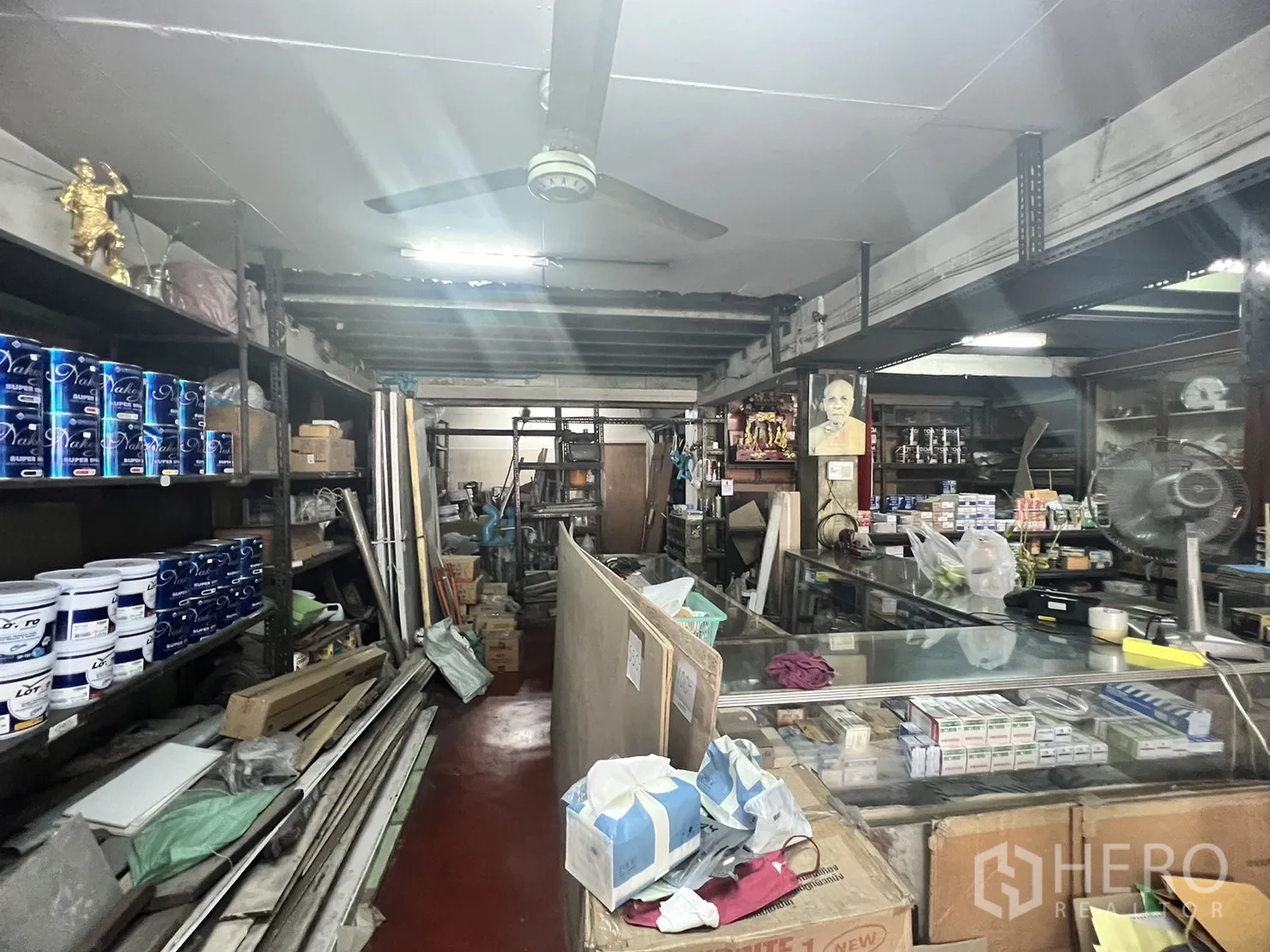 พื้นที่ขายปลีก ให้เช่าในWatthana, Bangkok - ทางเดินหลักของร้านมีเคาน์เตอร์ยาว พัดลมเพดาน และชั้นวางสีเรียงแถว