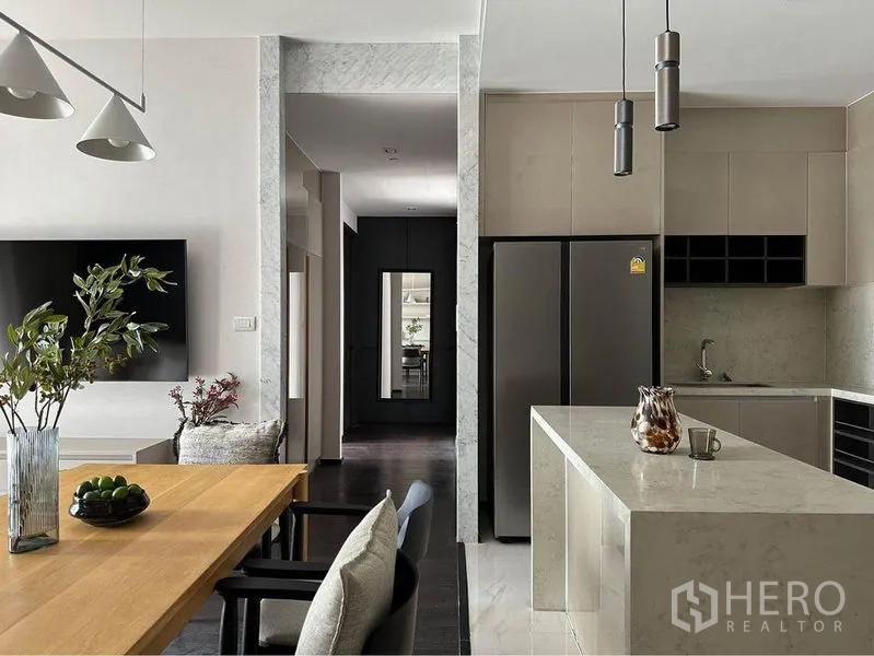 Condominium for rent or sale in Watthana, Bangkok - Open-plan kitchen and dining with marble island, double-door fridge and pendant lights.